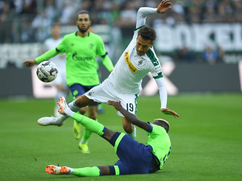 Borussia Mönchengladbach vs Schalke - US midfielder Fabian Johnson and Schalke's Moroccan defender Hamza Mendyl (bottom) fall down during the German First division Bundesliga football match between Monchengladbach and Shalke 04 on September 15, 2018 in Monchengladbach. (Photo by Patrik STOLLARZ / AFP)