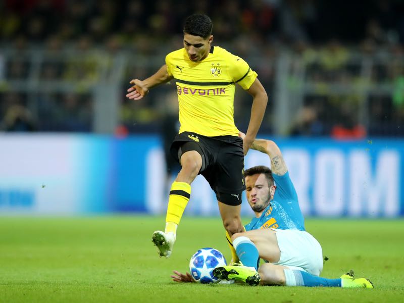 Borussia Dortmund v Atletico Madrid - Achraf Hakimi of Borussia Dortmund is challanged by Saul Niguez of Atletico Madrid during the Group A match of the UEFA Champions League between Borussia Dortmund and Club Atletico de Madrid at Signal Iduna Park on October 24, 2018 in Dortmund, Germany. (Photo by Christof Koepsel/Bongarts/Getty Images)