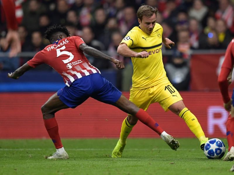 Atletico Madrid's Ghanaian midfielder Thomas (L) vies with Borussia Dortmund's German midfielder Mario Goetze during the UEFA Champions League group A football match between Club Atletico de Madrid and Borussia Dortmund at the Wanda Metropolitan stadium in Madrid on November 6, 2018. (Photo by OSCAR DEL POZO / AFP)