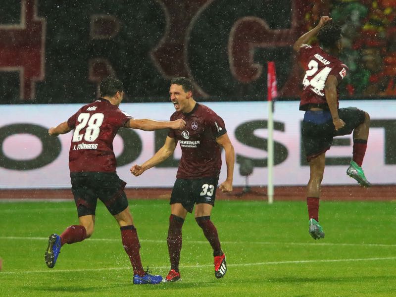 Nürnberg v Leverkusen - Georg Margreitter of Nuernberg (33) celebrates after scoring his team's first goal with Lukas Muehl (28) and Virgil Misidjan (24) during the Bundesliga match between 1. FC Nuernberg and Bayer 04 Leverkusen at Max-Morlock-Stadion on December 3, 2018 in Nuremberg, Germany. (Photo by Alexander Hassenstein/Bongarts/Getty Images)