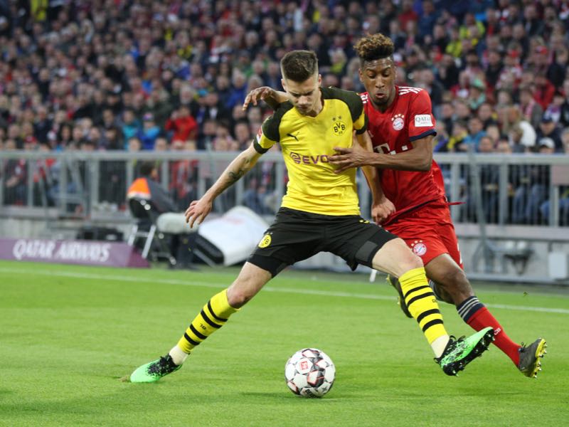 Julian Weigl of Borussia Dortmund is challenged by Kingsley Coman of Bayern Munich during the Bundesliga match between FC Bayern Muenchen and Borussia Dortmund at Allianz Arena on April 06, 2019 in Munich, Germany. (Photo by Adam Pretty/Bongarts/Getty Images)