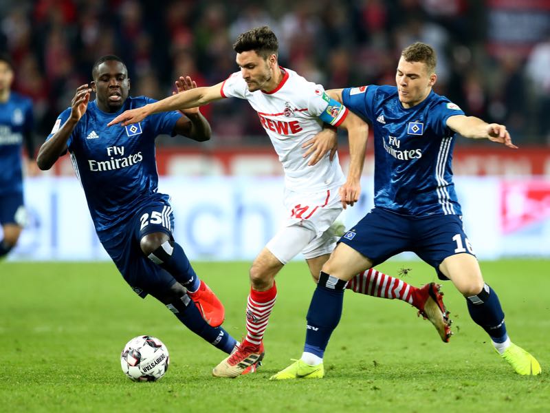 Köln v Hamburg - Jonas Hector (C) of Koeln challenge Orel Mangala and Vasilije Janjicic #16 of Hamburg during the Second Bundesliga match between 1. FC Koeln and Hamburger SV at RheinEnergieStadion on April 15, 2019 in Cologne, Germany. (Photo by Lars Baron/Bongarts/Getty Images)