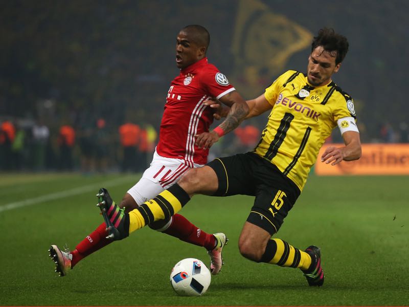 Mats Hummels of Dortmund is challenged by Douglas Costa of Bayern during the DFB Cup Final between Bayern Muenchen and Borussia Dortmund at Olympiastadion on May 21, 2016 in Berlin, Germany. (Photo by Lars Baron/Bongarts/Getty Images)